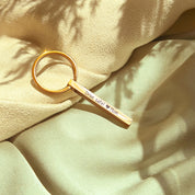 A gold mini 3D bar keychain resting on soft green fabric emphasizes the elegant, dainty keychain scale and polished edges. Crisp laser engraving along the side demonstrates readability on the smaller bar, while the spring key ring remains sturdy for daily use. Personalize this custom bar keychain with names, roman numerals, or GPS coordinates for anniversaries, travel mementos, or groomsmen sets.