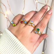 Model stylishly stacking the small oval ring collection. stack set, stacking rings, gemstone ring, birthstone ring, mother's day gift for her, gift for mom, gift for fiance, gift for girlfriend, wedding jewelry, bridesmaid jewelry, anniversary jewelry, anniversary gift, birthday gift, christmas gift, valentine's day gift, valentine's day rings, dainty ring, cocktail ring, statement ring, bezel set, birthstone jewelry, birthstone ring