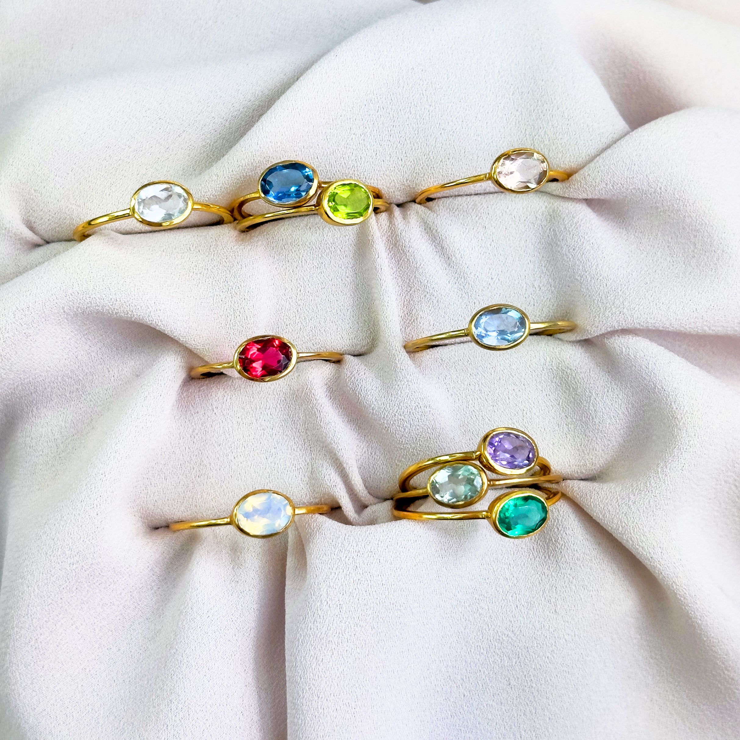Assorted gold small oval rings on beige background. stack set, stacking rings, gemstone ring, birthstone ring, mother's day gift for her, gift for mom, gift for fiance, gift for girlfriend, wedding jewelry, bridesmaid jewelry, anniversary jewelry, anniversary gift, birthday gift, christmas gift, valentine's day gift, valentine's day rings, dainty ring, cocktail ring, statement ring, bezel