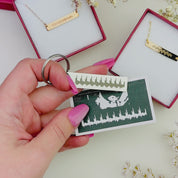 A video of A mom holds a keychain with her childs sonogram engraved. She is also holding a photo of an ultrasound with the sonogram visible on the photo. Personalized baby keychain, baby heartbeat keychain, sonogram keychain, engraved baby keychain