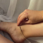 Model layering multiple birthstone gold anklets. One gold anklet with 3mm amethyst, moonstone and pink chalcedony.