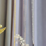 3 dainty 3D bar necklaces hanging and swaying show off three metal finishes - sterling silver, gold vermeil and rose gold vermeil. Necklaces appear on a mix of satellite beaded and simple cable chains to show variety of options. Each side of these bar necklaces can be personalized with your custom engraving wishes. This is perfect for a mother with her kids' names engraved on each side!