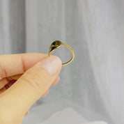 A hand holds and rotates a gold constellation ring, showing the curve of the disc. The ring is curved to comfortably fit on the finger, and the engraving is permanently etched into the surface for maximum long term durability. These rings can be engraved with any zodiac constellation and are made to order, completely personalized for your unique style. Available in sterling silver, rose gold, or gold vermeil, these rings are hypoallergenic and designed to be comfortable and stylish.