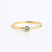 Single gold plated blue topaz gemstone dainty 3mm ring. December birthstone ring on white background.