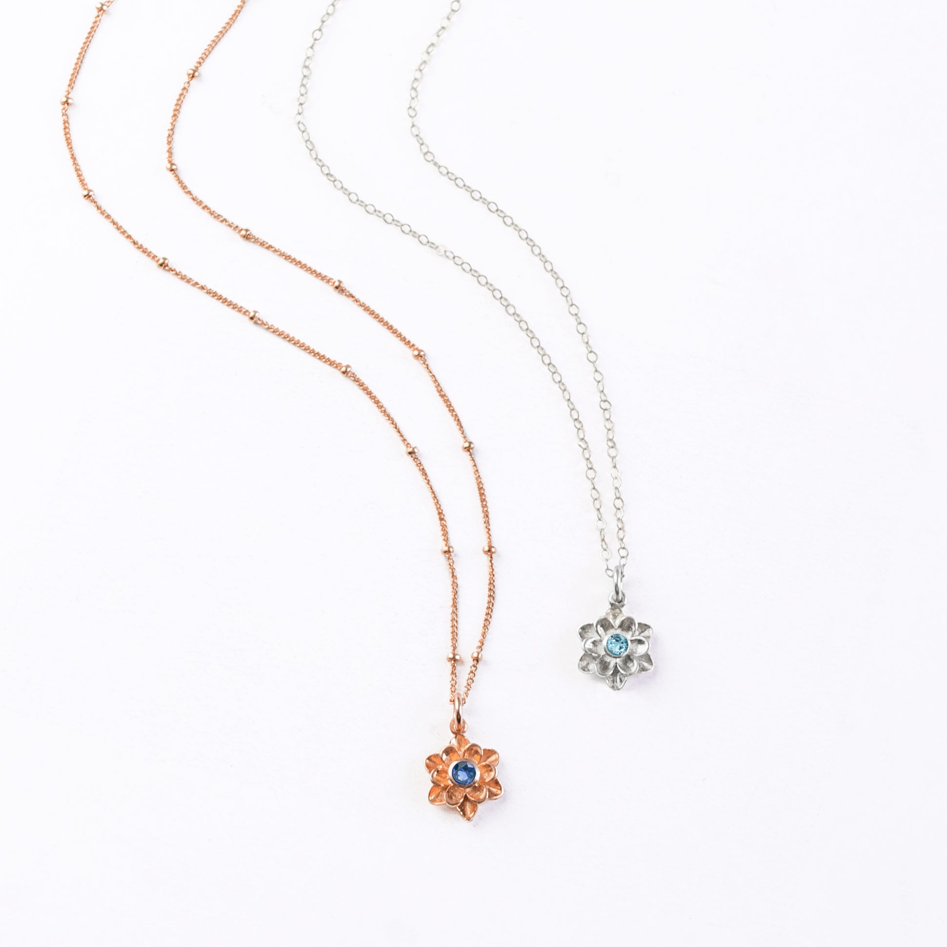 Rose gold filled satellite chain with large flower bloom pendant and kyanite birthstone. Sterling silver cable chain with large floral bloom pendant and blue quartz birthstone.