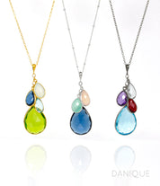 Single gold filled cable style cascade chain with large mother's peridot birthstone and three kid's stones including moonstone, kyanite and blue topaz. Middle necklace is sterling silver satellite chain with kyanite mother stone, aqua and pink chalcedony for children's stones and a oxidized cascade necklace with blue topaz, clear, purple amethyst and ruby birthstones