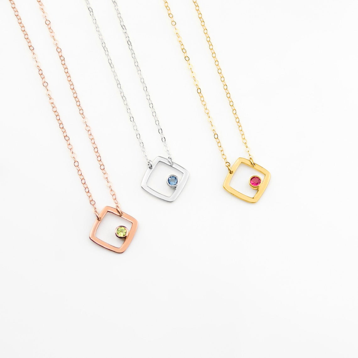 gold plated open square minimalist necklace with ruby birthstone, july birthstone july gemstone. birthstone jewelry. minimalist jewelry. sterling silver open square with iolite birthstone, rolse gold plated open square necklace with peridot birthstone. august birthstone.