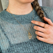Model is wearing a gold plated butterfly wing pendant with aqua chalcedony, pink chalcedony and moonstone birthstones on a satellite style chain.