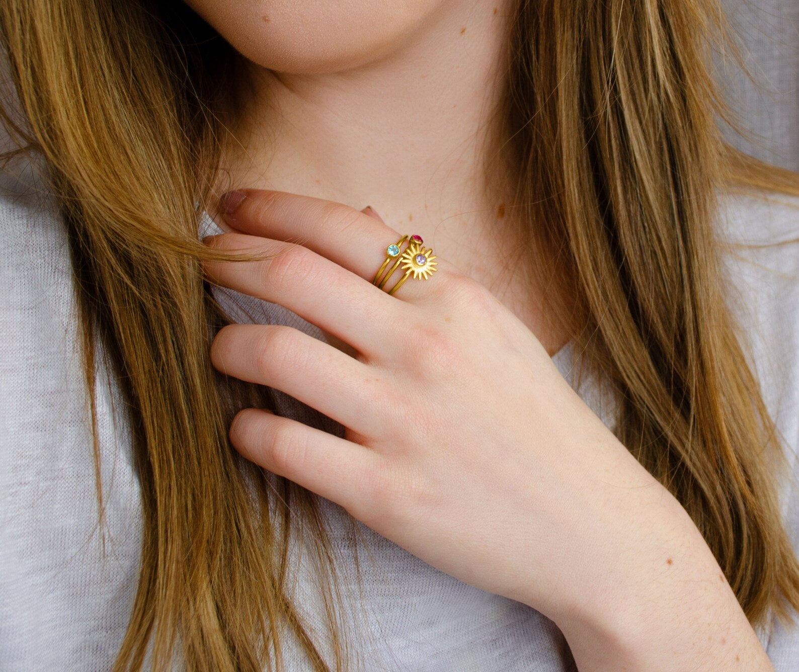 Mix and match these dainty 3mm birthstone bezel rings! Model is stylishly stacking moonstone sun burst and blue topaz and ruby tiny round rings.