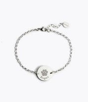 Engrave your fur baby's paw print on this silver anklet disc featuring a stock print and name in typewriter font.