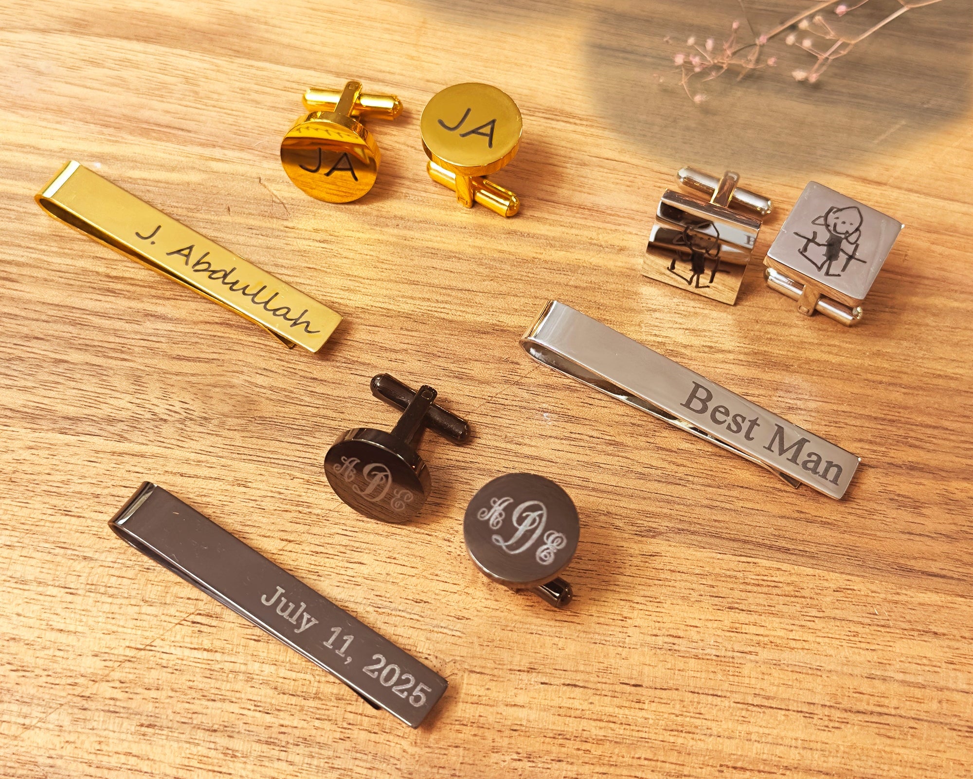 Personalized groomsmen gift sets featuring custom engraved tie clips and cufflinks. Metal finishes include gold, silver, and black with options for names, dates, and custom art.
