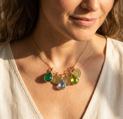 Model wearing a personalized family birthstone necklace with initial charms, styled as a meaningful gift for mom or grandma.