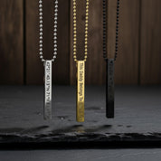 Three 3d Bar necklaces in silver with coordinates in block font, gold with a custom phrase in modern thin font, or black with names engraved in typewriter font.