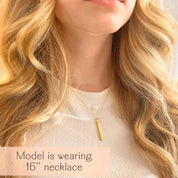Lifestyle view of a woman wearing a single dainty gold custom bar necklace, the 3D pendant resting at collarbone length for effortless daily wear. Personalize with initials, children’s names, wedding date or Roman numerals to create a modern name bar necklace. Great for birthdays, anniversaries, graduations and thoughtful mothers necklace with names alternatives in a clean, minimalist silhouette.