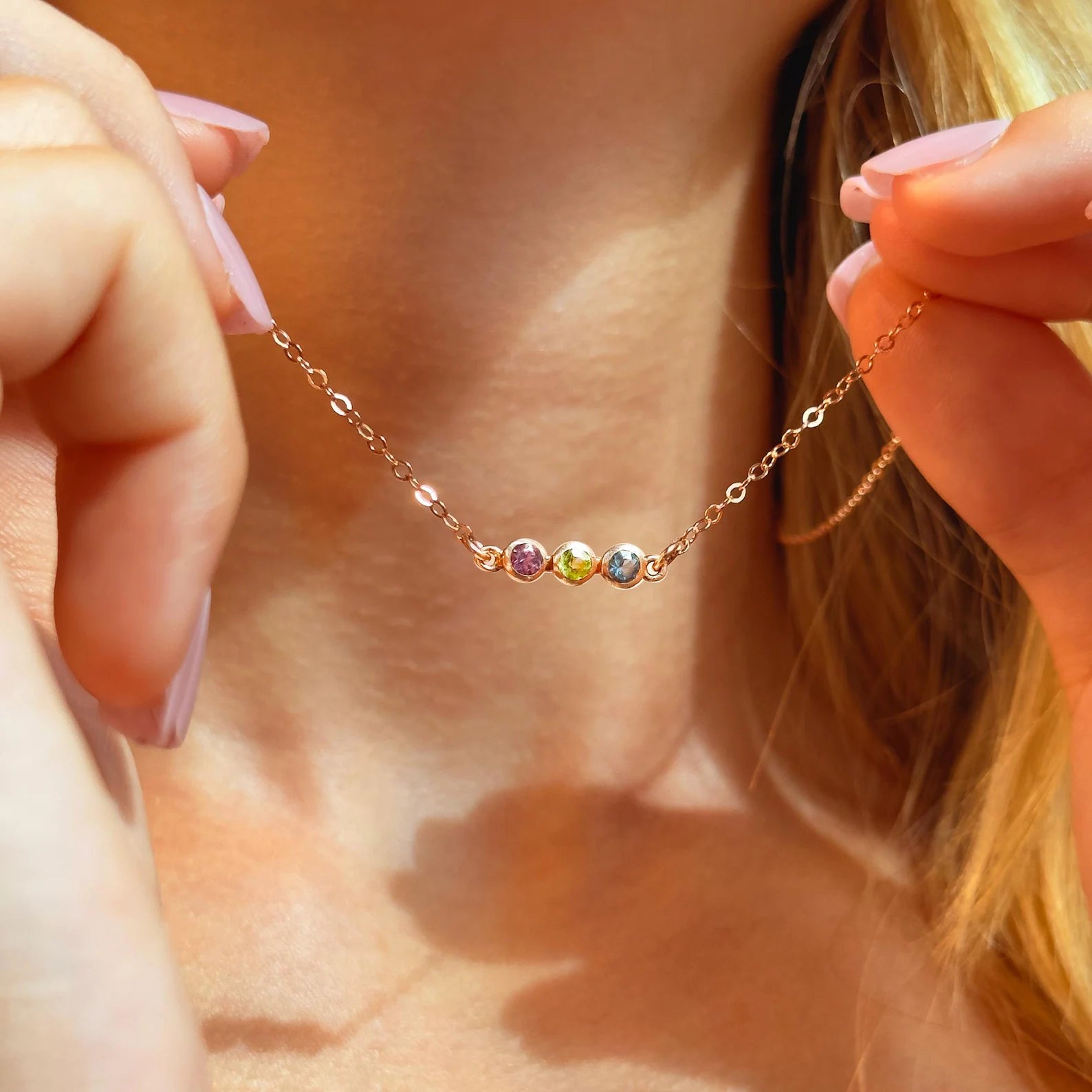 Dainty gold birthstone bar necklace with faceted gemstones, personalized family jewelry for mom with multiple colorful stones set in a sleek minimalist bar pendant on a fine chain