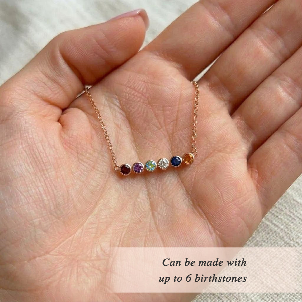Macro detail of faceted gemstone birthstone bar necklace, highlighting colorful stones and fine gold chain in a modern minimalist family jewelry design