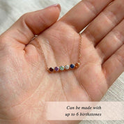 Macro detail of faceted gemstone birthstone bar necklace, highlighting colorful stones and fine gold chain in a modern minimalist family jewelry design