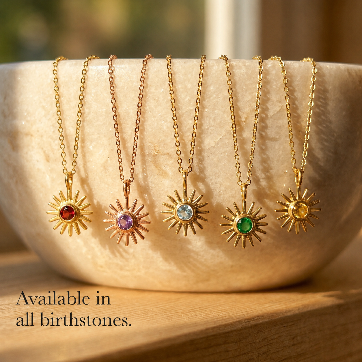 Custom birthstone sunburst necklaces shown in all birthstone colors on gold chains