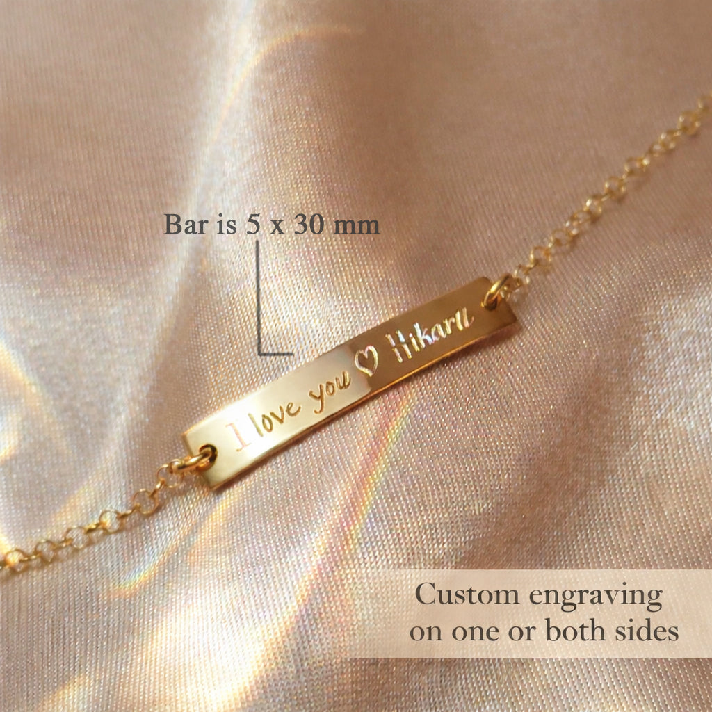 Close up of engraved name bar charm bracelet, precision custom engraving on minimalist gold bar jewelry