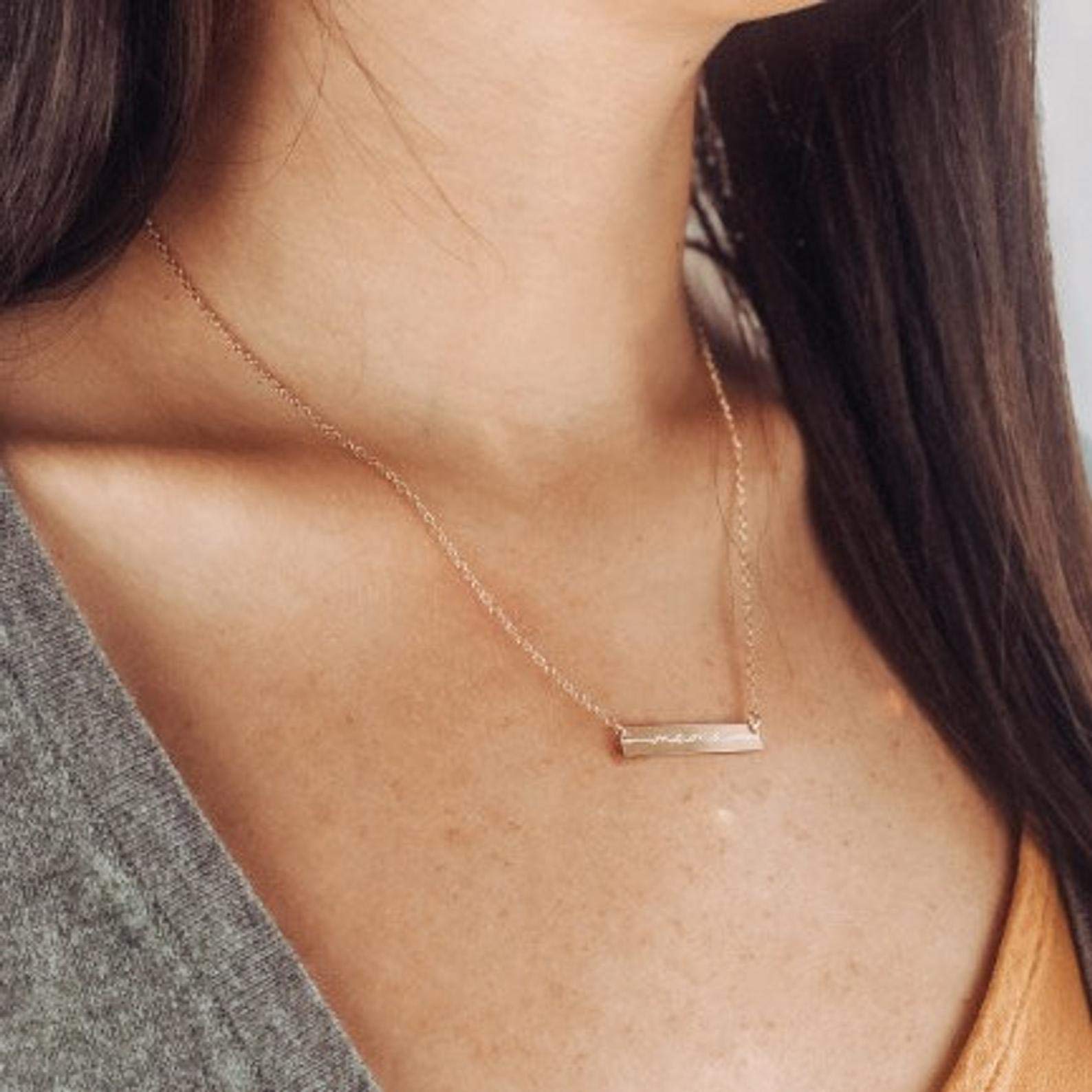 A person with long brown hair is wearing a custom engraved bar necklace. Personalized bar necklace custom engraved nameplate necklace custom mama necklace for new mom, bar necklace, push present for new mom, push present ideas. Minimalist engraved name necklace Personalized bar pendant Custom engraved bar necklace for women Minimalist engraved coordinates necklace Personalized vertical bar pendant Engraved horizontal name bar necklace