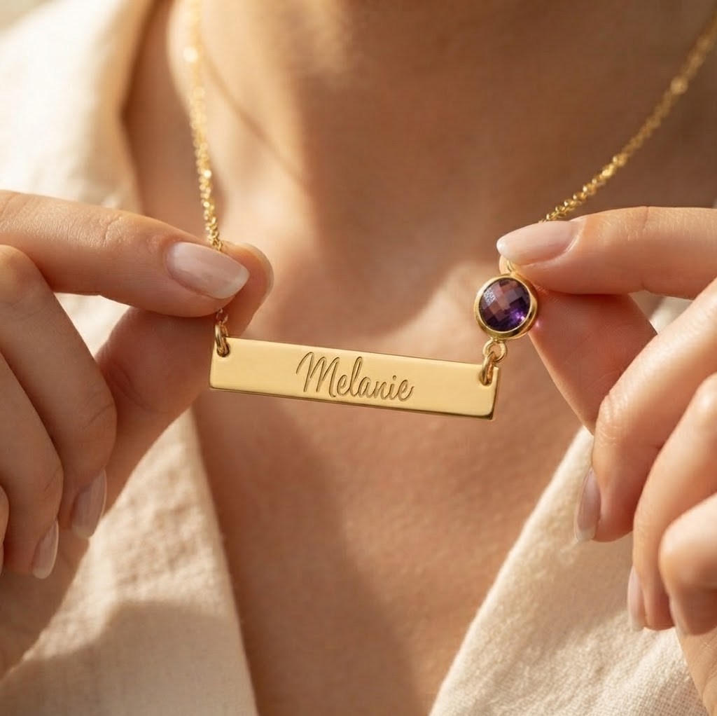 Gold engraved name bar necklace with Melanie and purple round birthstone worn by woman