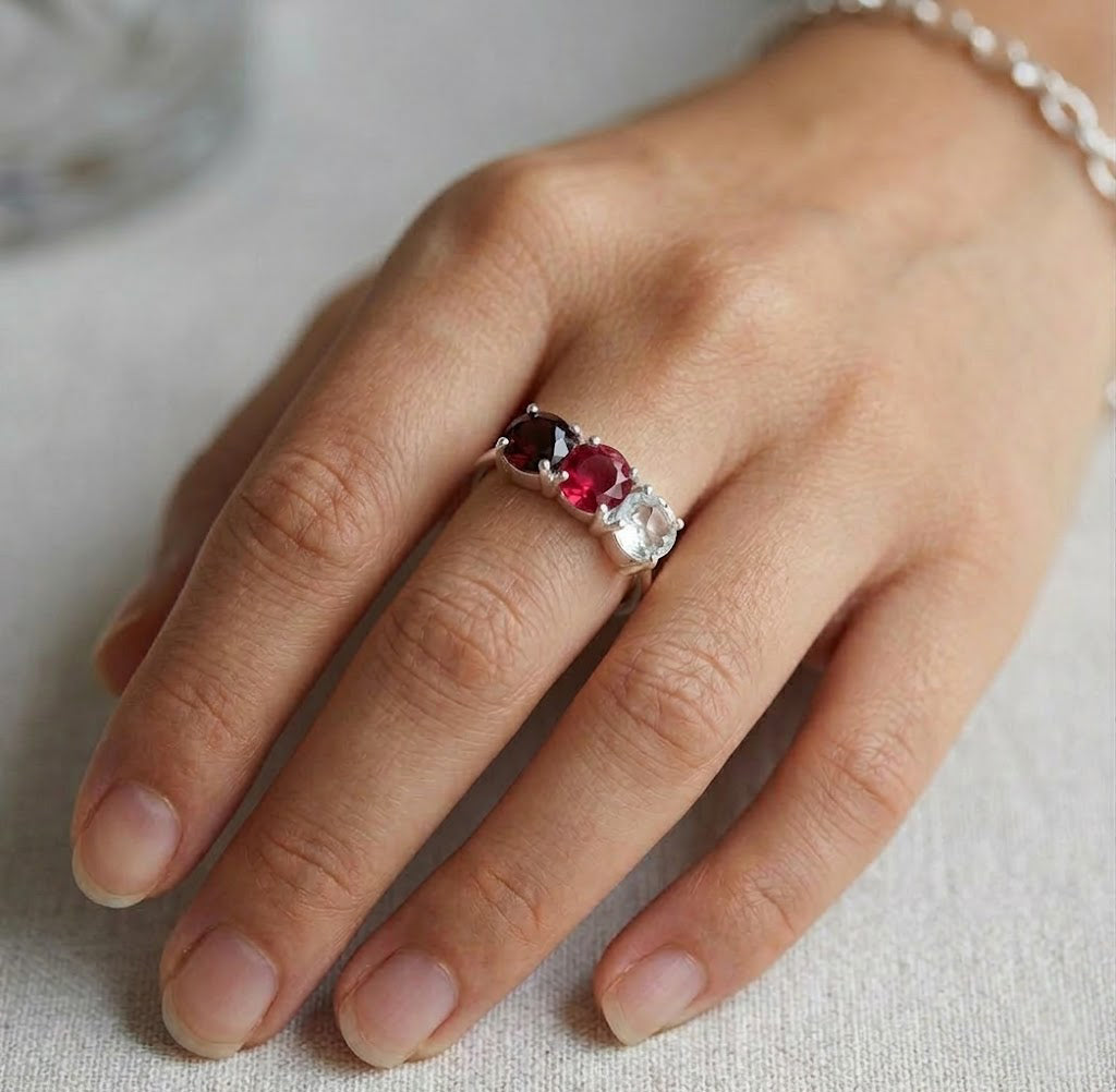 Custom three birthstone ring for mom in gold, dainty family gemstone ring on white background