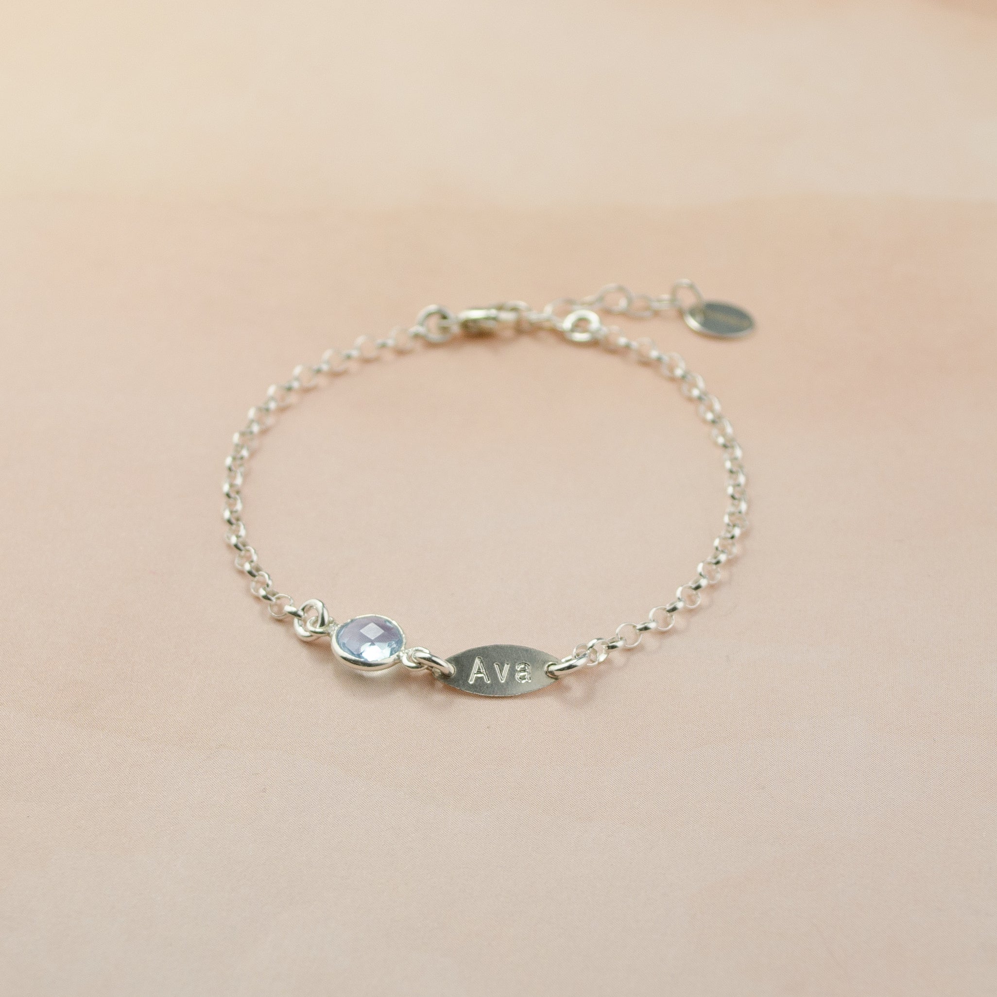 Single sterling silver marquise tag bracelet with small round 6mm sky blue birthstone.