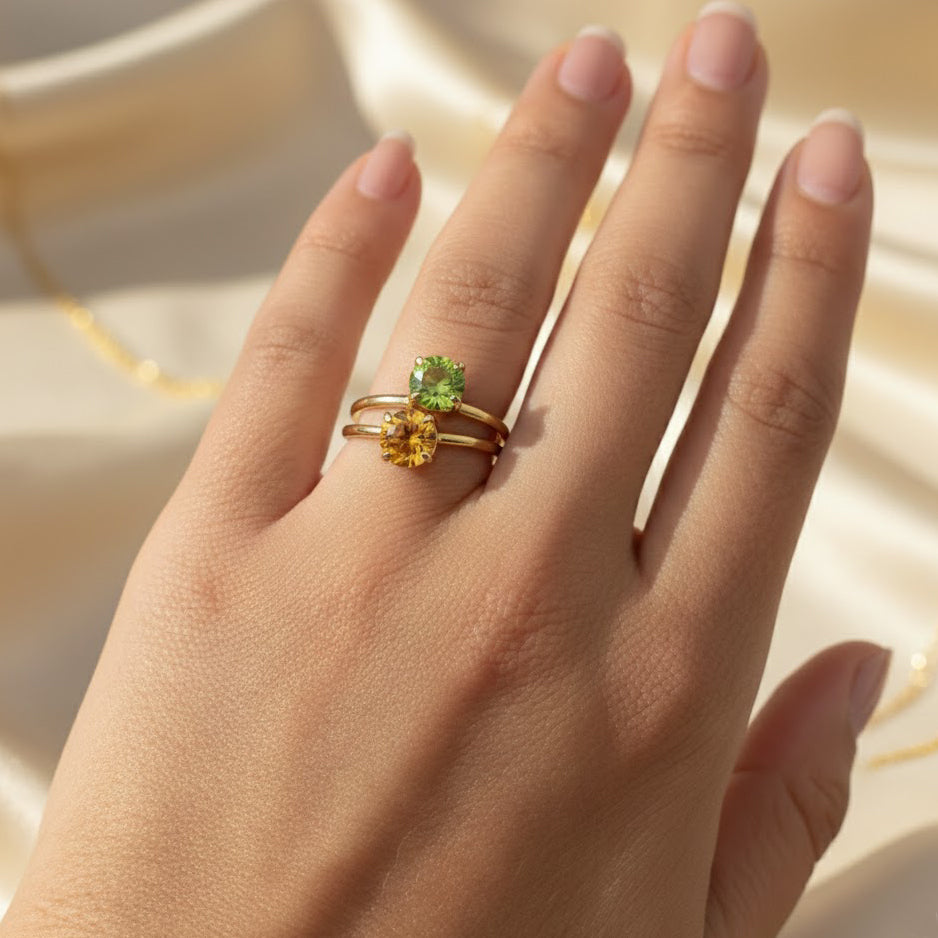 woman’s hand wearing three stackable birthstone rings — minimalist gold vermeil bands each set with a vibrant birthstone gem, representing children’s birth months, personalized stacking ring for mom or grandma, gift-ready design in sterling silver or gold, perfect for everyday wear or special occasions like mother’s day, birthdays, growing family keepsake