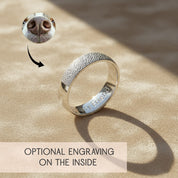 Custom sterling silver pet nose print ring on beige background, showing realistic dog nose texture wrapped around band with optional inside engraving, personalized memorial jewelry for dog or cat lovers, unique pet keepsake ring.