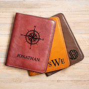 Three Natural Leather passport holders in rich cinnamon, sweet honey and earthy espresso rest against a natural wood background. Each passport sleeve is custom Monogrammed and engraved. The cinnamon passport holder has a compass and the name Jonathan in Classic font. The honey has the intials SWE engraved in our Timeless Monogram format. The espresso passport cover is engraved with the initials JGA in our Spherical Monogram format.