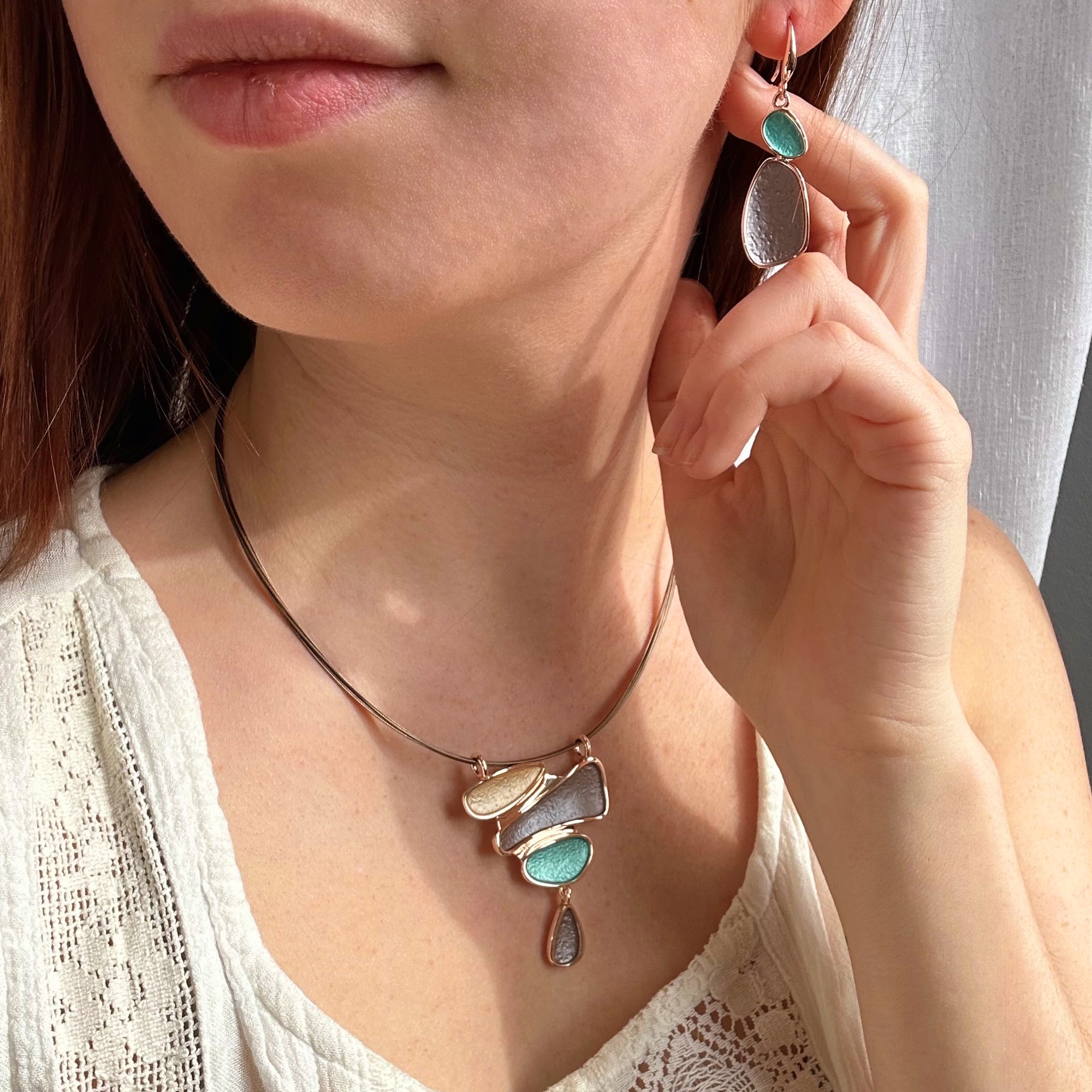 Model wears matching Boho Abstract Teardrop rose gold necklace and earring set.