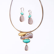 Matching Earring and Necklace Set. Earrings are dangle earrings with two oval shapes painted in teal and brown. Necklace is a pendant with three organic shapes and a dangling teardrop painted in gold, brown, and teal. Necklace has a copper wire chain