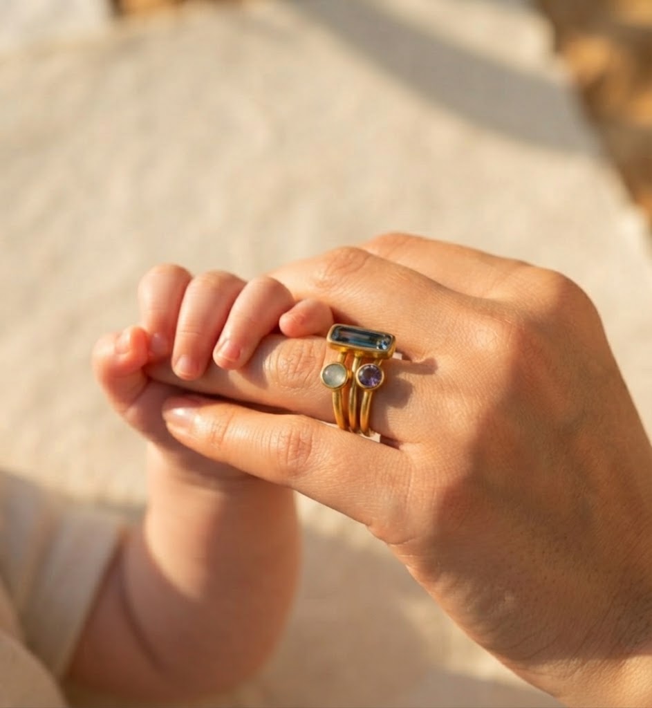 Custom family birthstone ring stack worn on hand
