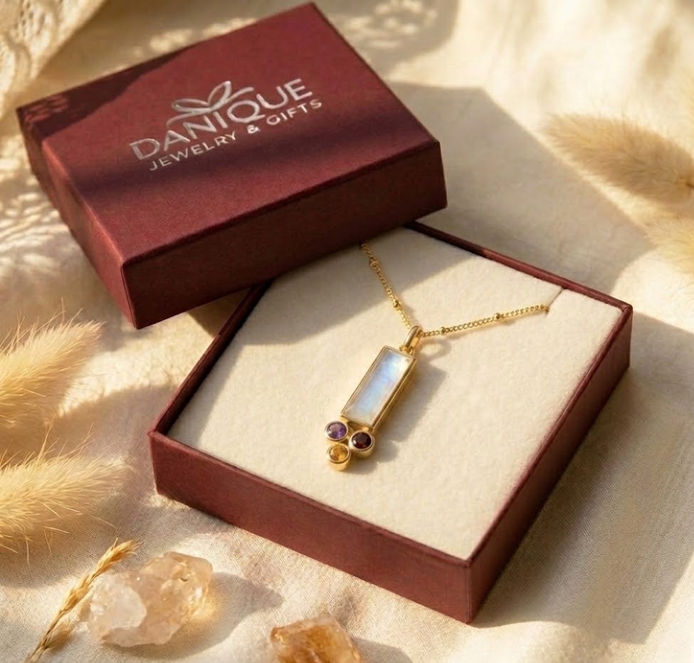 Custom mom birthstone necklace in a Danique Jewelry gift box with baguette gemstone pendant and tiny kids’ birthstone charms, ready for gifting in Danique Jewelry branded box