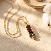 Mother and child lifestyle photo featuring a custom birthstone family necklace with a baguette mom stone and small kids’ birthstone charms.