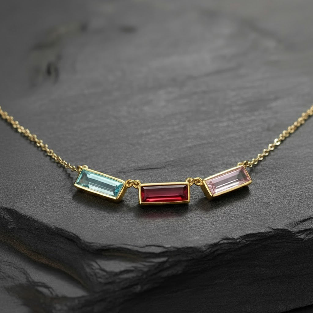 mom birthstone name necklace featuring three slim vertical bar gemstones bezel set in gold and arranged side by side on a delicate chain, icy blue, deep ruby red and soft blush pink birthstones representing children or family members, modern minimalist bar design perfect for personalized mom jewelry, custom birthstone and name combinations available, meaningful Mother’s Day, birthday or Christmas gift that layers beautifully with other necklaces
