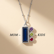 Birthstone necklace for mom with labeled design showing the baguette stone for “Mom” and small side charms for “Kids.”