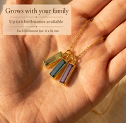 Personalized birthstone necklace for Mom with three engraved name bars shown on soft neutral fabric.