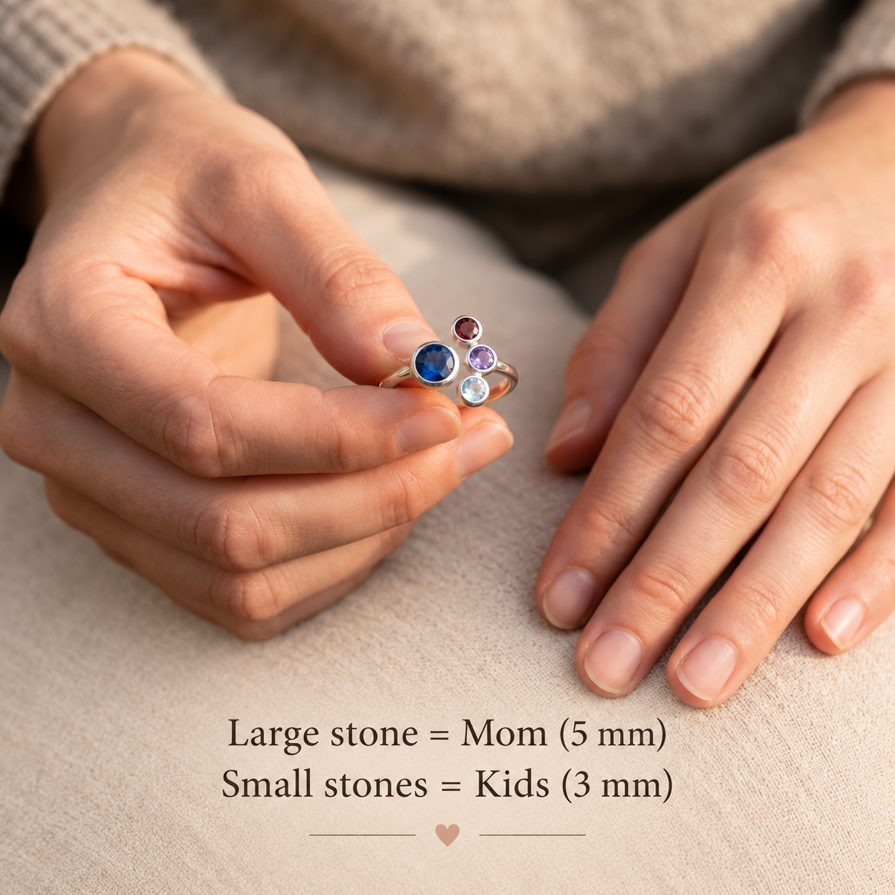 Custom Mom of three birthstone ring showing one large 5 mm Mom stone and three smaller 3 mm kids birthstones.
