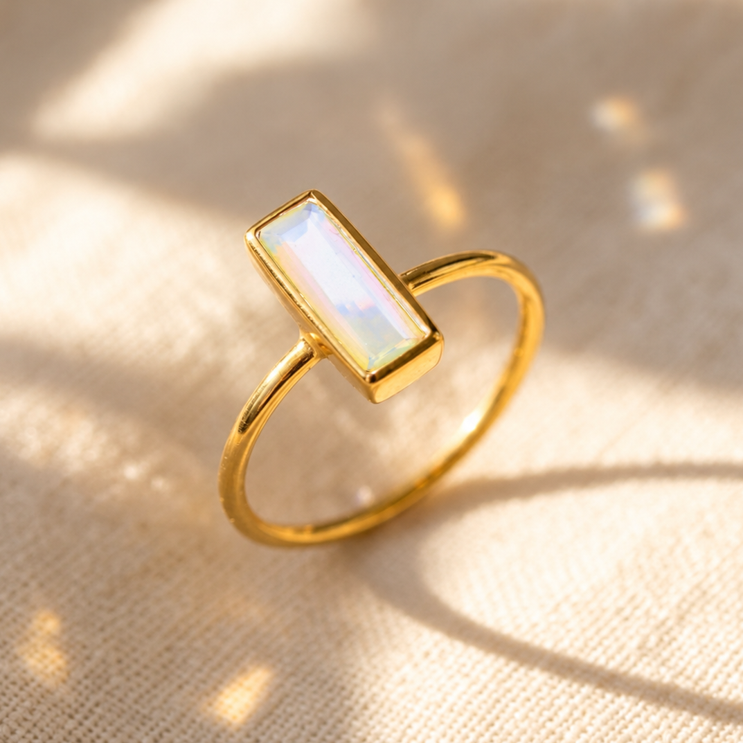Tiny Opalite bar ring in yellow gold with a slim iridescent rectangular October birthstone gemstone.
