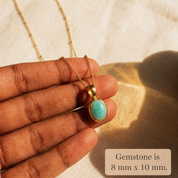 Amazonite oval cabochon necklace shown in hand with 8 x 10 mm gemstone size note.