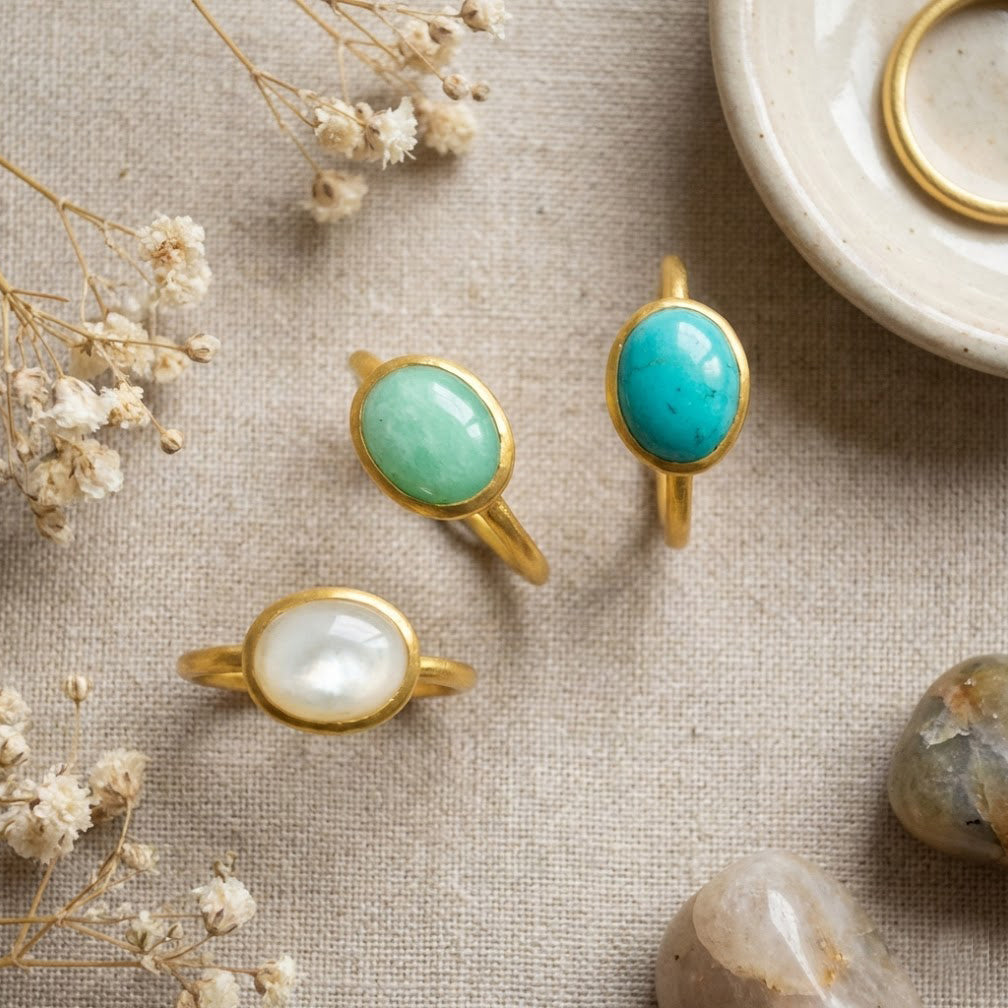 Amazonite gemstone jewelry displayed together, featuring an oval amazonite ring and coordinating stone pieces. Smooth cabochon turquoise stones set in gold, designed as minimalist gemstone jewelry for women and elegant everyday accessories.