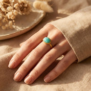 Oval amazonite ring worn on the hand, featuring a smooth cabochon amazonite gemstone set in a minimalist gold bezel. Dainty turquoise blue stone ring designed for everyday wear, crafted as a modern gemstone ring for women. Elegant amazonite jewelry ideal as a gift for her, December birthstone alternative, or meaningful minimalist statement ring.