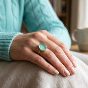 Aqua chalcedony statement ring worn on the hand with a large blue green teardrop gemstone.
