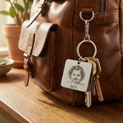 Personalized baby photo keychain attached to a leather handbag, showcasing everyday use of an engraved baby picture keepsake. This custom photo keychain is engraved from a real baby photograph and crafted in stainless steel for durability. A meaningful new mom keepsake gift that allows parents and grandparents to carry a cherished baby portrait wherever they go.