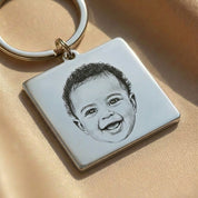 Close-up of an engraved baby portrait on a square stainless steel photo keychain, highlighting the detail and clarity of the baby’s facial features. This custom baby photo keychain is engraved from a real photograph and designed as a sentimental keepsake gift for new moms, grandparents, or baby memorial jewelry, preserving special moments in a timeless form.