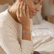 Woman wearing a custom birthstone bracelet featuring larger 4mm bezel-set gemstones on a delicate chain. Personalized family bracelet designed with children’s birthstones, handcrafted in sterling silver or gold vermeil. Elegant everyday jewelry gift for mom or grandma, combining minimalist style with meaningful personalization.