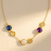 Mom necklace with custom birthstones and initial charms in gold on beige background