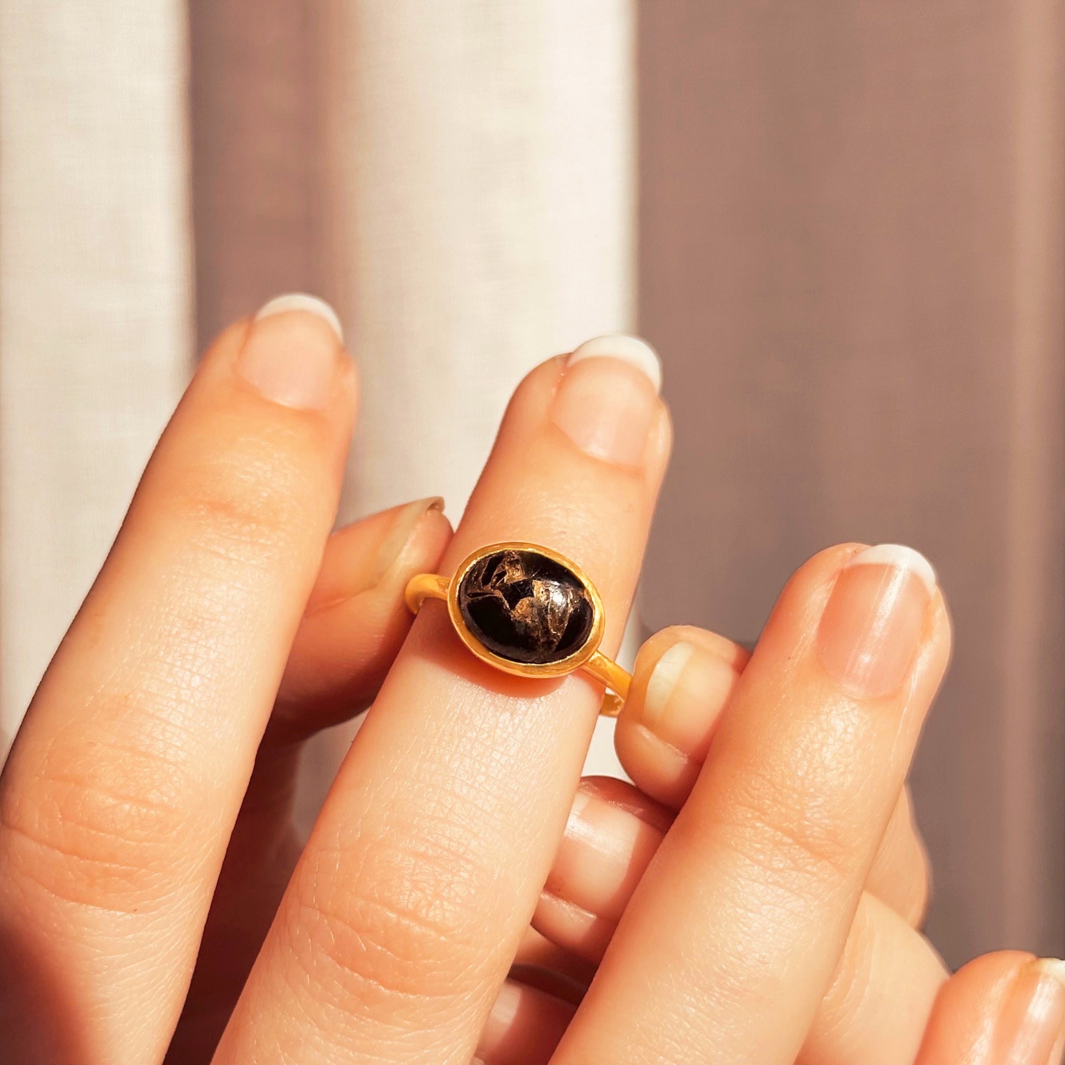 Model placing a Ring with Black Obsidian cabochon with Copper Inclusions on hand. 18K Vermeil Gold Black Copper Obsidian Oval Ring, Clarity Crystal Gemstone Jewelry,  Black Copper Obsidian Solitaire Ring, Dainty Gold Stacking Ring Gift for Her