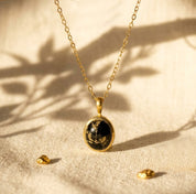 Natural Black Copper Obsidian oval necklace in yellow gold vermeil on beige fabric